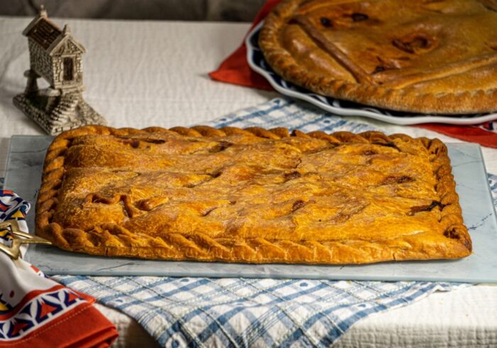 Empanada gallega Gourmet entera sobre plato tradicional, masa dorada y horneada a mano